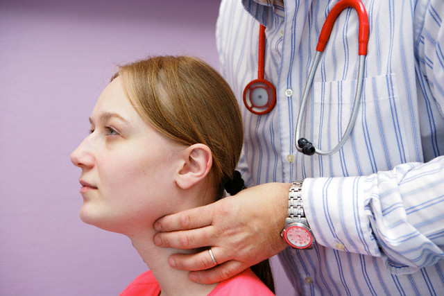 Doctor Checking Patient's Thyroid