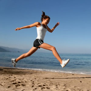 Happy girl running alone on the beach